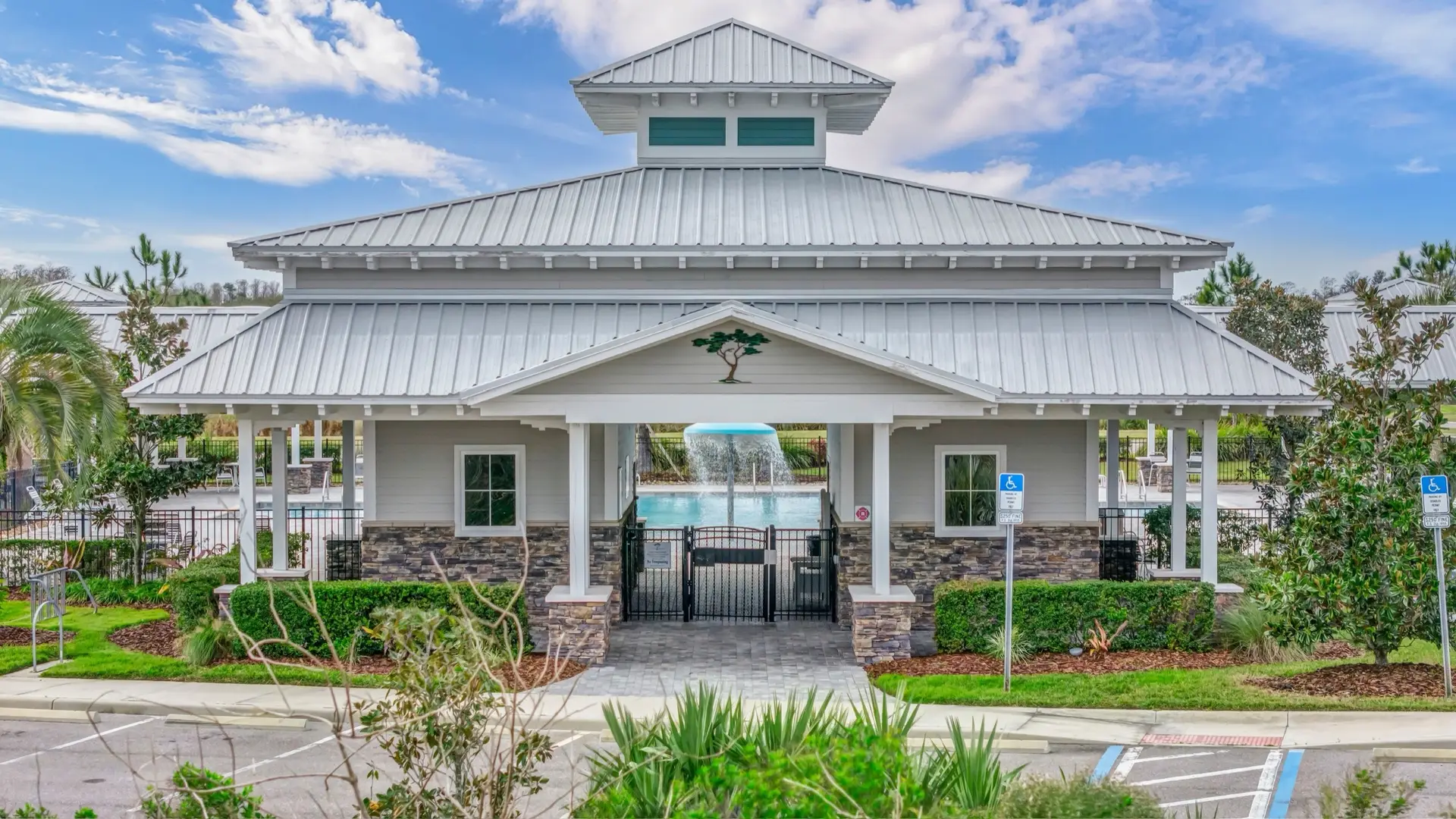 A white clubhouse with a wide porch and a cupola